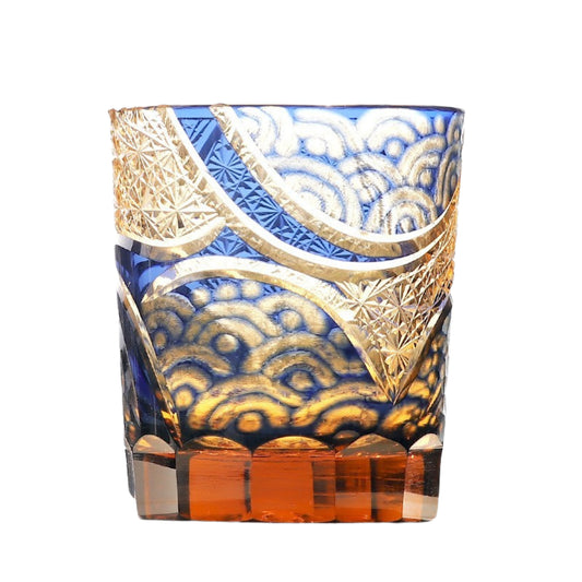 Blue handcrafted whiskey glass with gold latticework and amber base
