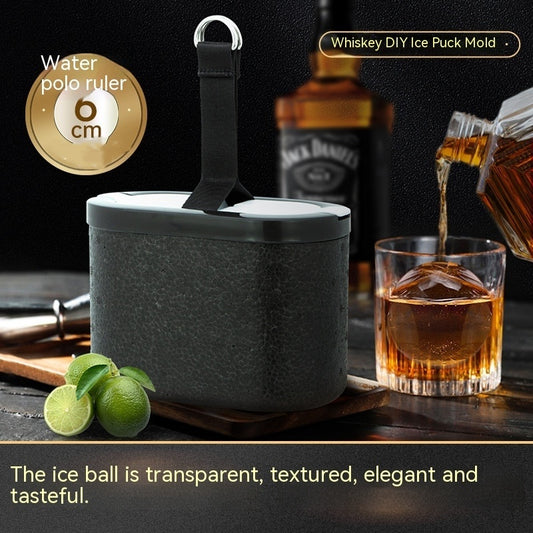 Whiskey ice ball mold with lid, limes, and a transparent ice sphere in a glass of whiskey.